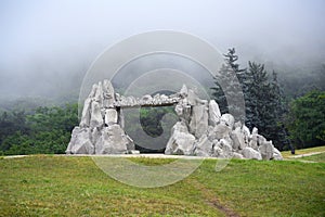 Stone gate at Mashuk Mount in mist, Pyatigorsk, Stavropol Krai, Russia. Misty scenery in forest of Caucasian Mountains in summer. photo