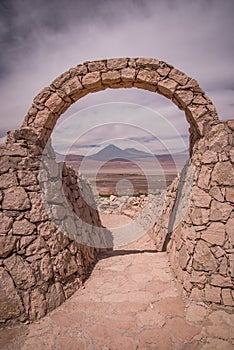 Stone gate at Pukara de Quitor - Inca fortress at Atacama desert with the view at Licancabur volcano in Andes, San Pedro de Atacam photo