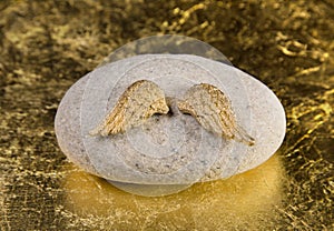 Stone with golden angel wings: greeting card for die, death, com