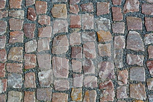 Stone granite cobblestoned pavement background or texture. Abstract background of old cobblestone pavement close-up in Prague