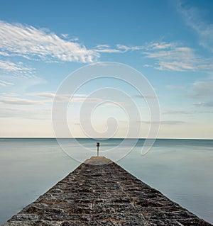 Stone Groyne with calm seas and blue skies photo