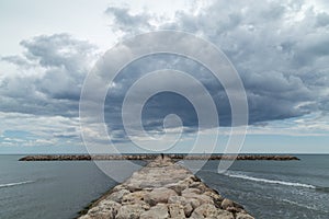 Stone Groyne Pier at Camargue with Dramatic Clouds above Sea