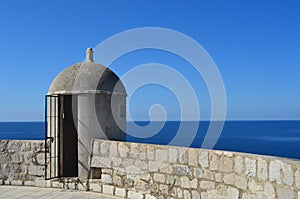 A stone guard tower overlooking a blue sea