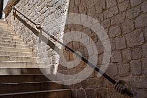 Stone hand holding stairway railing in the Rectors Palace in Dubrovnik, Croatia