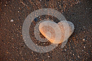 Stone heart on the pebble beach. Love concept. Valentine background