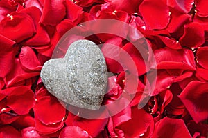 Stone heart in rose petals