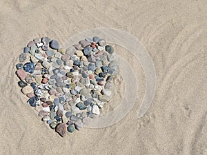 Stone heart in sand on beach