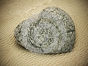 Stone heart standing on beach sand. 3D illustration