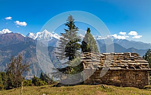 Stone house with Himalaya mountain snow peaks at the background at Uttarakhand India