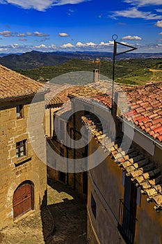 Stone houses and terraced fields by Iglesia de Santa Maria church in Ujue, Spain