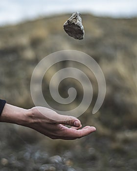 Stone hovering over the arm. A stone thrown into the air. Gravity