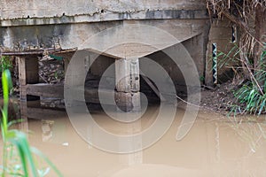 Stone, hump backed bridge over the river Kishon, Israel. The river gently trickles through the archway.