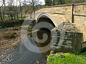 Stone, hump backed bridge over the river Nidd, Pateley Bridge, UK