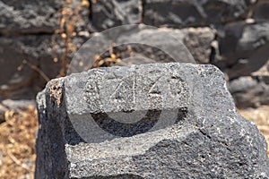 Stone  with the inscription Azizo in ruins of the main hall of the Dir Aziz Synagogue, built in the Byzantine period, at the photo