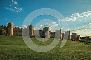 Stone large wall with towers over hilly landscape in Avila