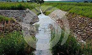 Stone lining of bank at the mouth of the sewer pipe with a grate against the entry of persons into the treatment plant or industri