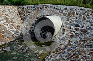 Stone lining of bank at the mouth of the sewer pipe with a grate against the entry of persons into the treatment plant or industri