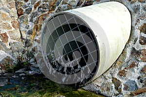 Stone lining of bank at the mouth of the sewer pipe with a grate against the entry of persons into the treatment plant or industri