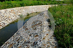 Stone lining of bank at the mouth of the sewer pipe with a grate against the entry of persons into the treatment plant or industri