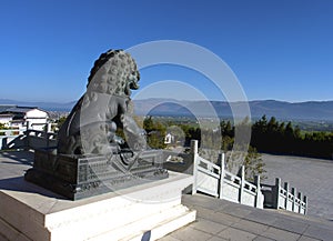 Stone lion statue overlooking city