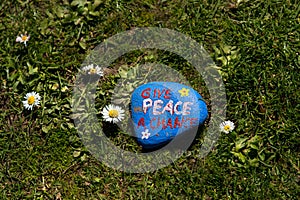 A stone with a logo Give peace a chance