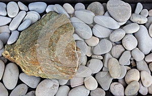 Stone, lying on a surface lined with stone pebbles