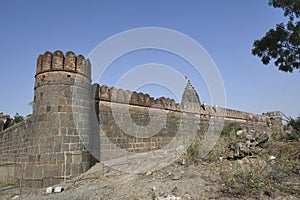 Stone masonry wall with Cylindrical watch towers at intervals surrounding entire village of  Vitthal Temple, Palashi, Parner,