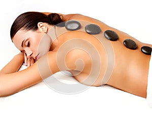 Stone Massage. Beautiful Woman Getting Spa Hot Stones Massage in