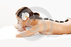 Stone Massage. Beautiful Woman Getting Spa Hot Stones Massage