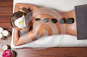 Stone massage. Beautiful woman getting spa hot stones massage in spa salon.