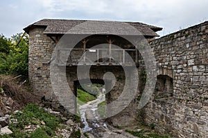 Stone medieval gates with a stone wall next to.