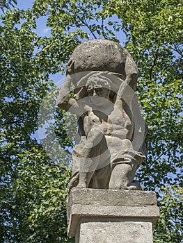 Stone men figure carrying stone, baroque statue from Greek mythology of Sisyphus or Sisyphos