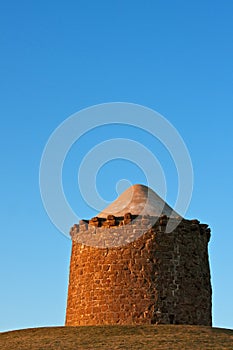Stone monument on a hilltop at sunset