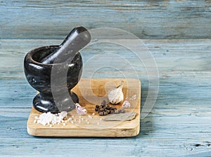 Stone mortar with a pestle on a wooden cutting board