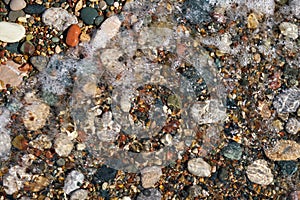 Stone natural background. Wet pebble stones in water