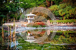 Stone ornament in Japanese garden is reflected in pond