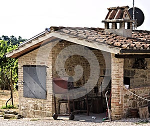 A stone oven with iron utensils for grilling meat with roof tiles and bricks in a farmhouse Umbria, Italy