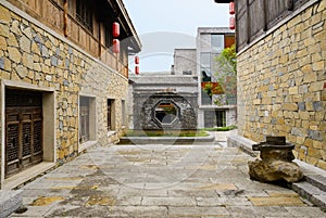 Stone path between archaised buildings in cloudy afternoon