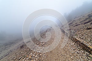 Stone path in the mountain on a day of intense fog and atmosphere of mystery. Morcuera photo