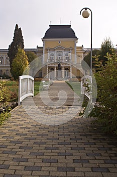 Stone pathway leading towards yellow building.