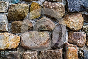 Stone pattern in different sizes and colors, wall made of quarry rocks and cement, modern garden architecture
