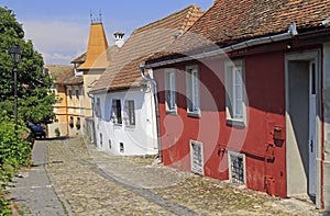 Stone paved old street with colorful houses in Sighisoara fortress