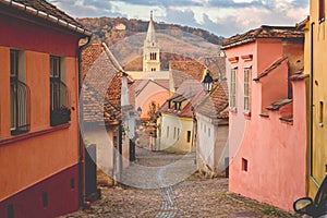 Stone paved old streets with colorful houses in Sighisoara fortress, Romania