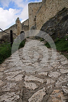 Kamenná dlážděná cesta vedoucí ke starobylé pevnosti na kopci