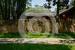 Stone-paved path outside enclosed tile-roofed house in sunny sum