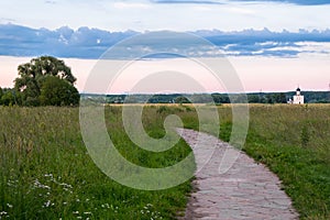 The stone-paved trail through the Bogolubovo meadow towards Church of the Intercession of the Holy Virgin on the Nerl River.