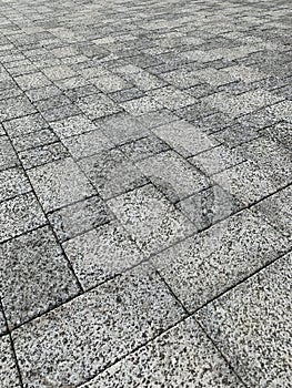 Stone pavement in perspective. Stone pavement texture. Granite cobblestoned pavement background.