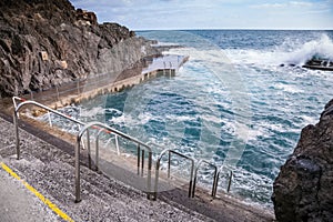 Stone pavement with railings descent to sea