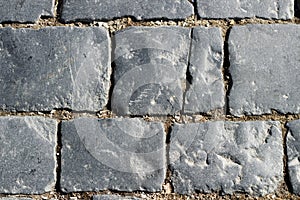 Stone pavement texture, granite cobblestoned pavement background, cobbled stone road regular shapes, abstract background