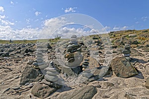 Stone pebble cairns on a sandy beach